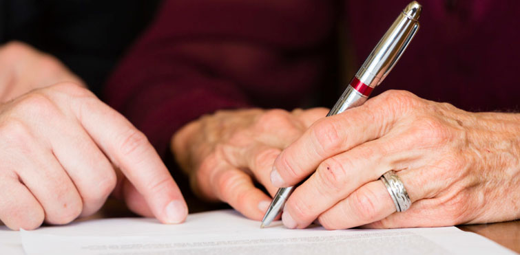 Elderly individuals signing a legal document